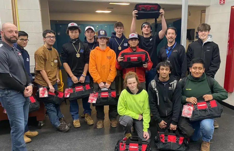 Gabe's electrical team in High school smiling with toolbags.